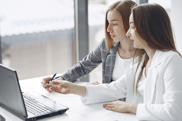 two property managers working on a marketing plan on a shared laptop